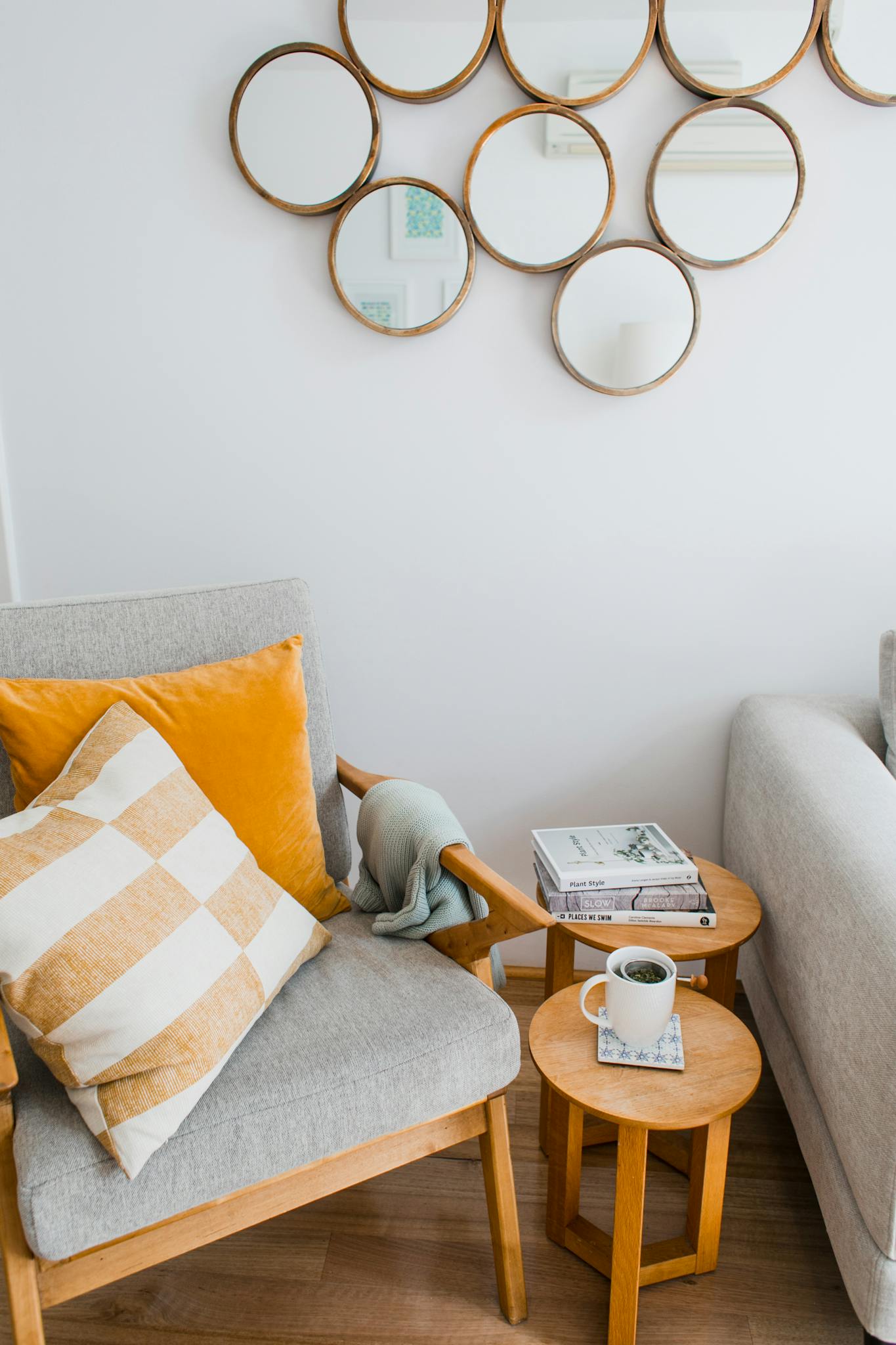 Modern living room featuring a cozy armchair, stylish mirrors, and a coffee table.